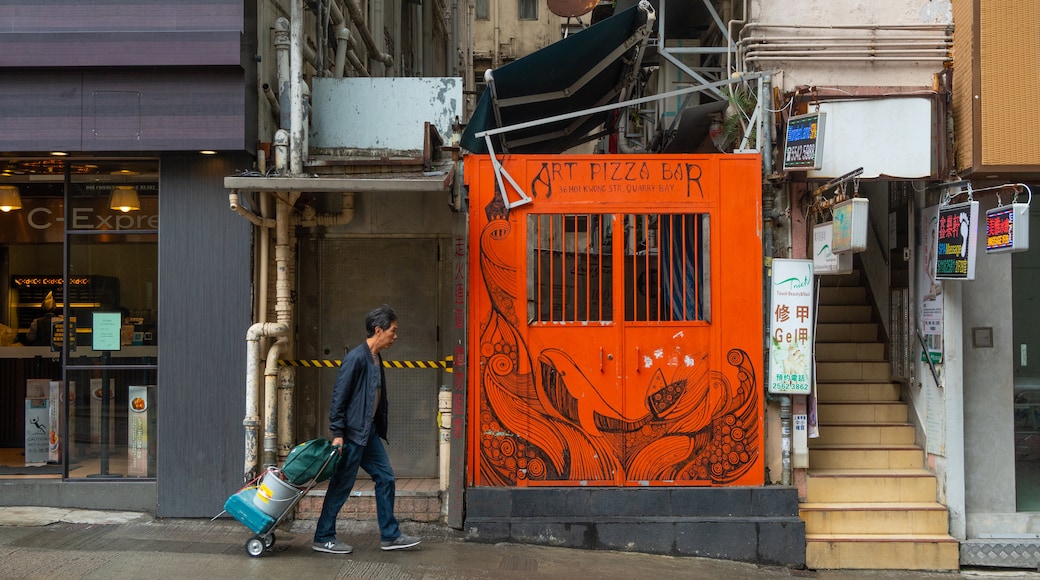 Quarry Bay featuring street scenes and signage as well as an individual male