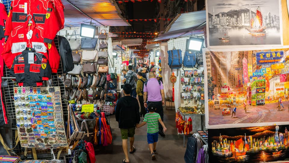 Temple Street Night Market showing night scenes and markets as well as a family