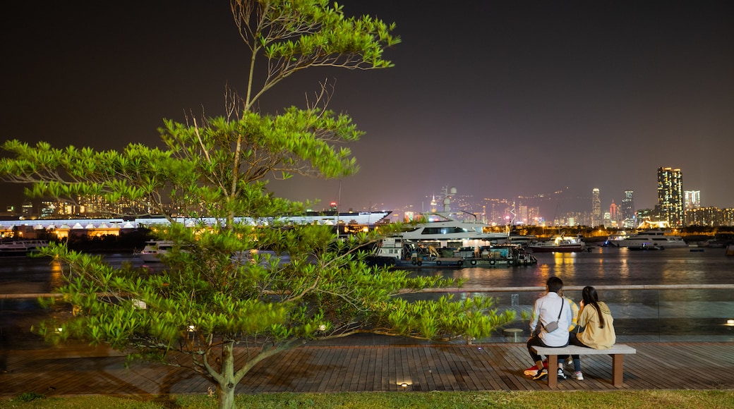 Kwun Tong Promenade featuring night scenes and a bay or harbor as well as a couple