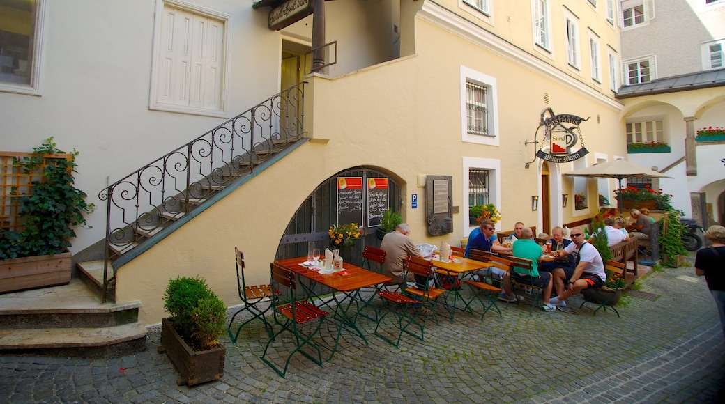 Calle comercial Getreidegasse que incluye escenas cotidianas, un bar y comidas al aire libre