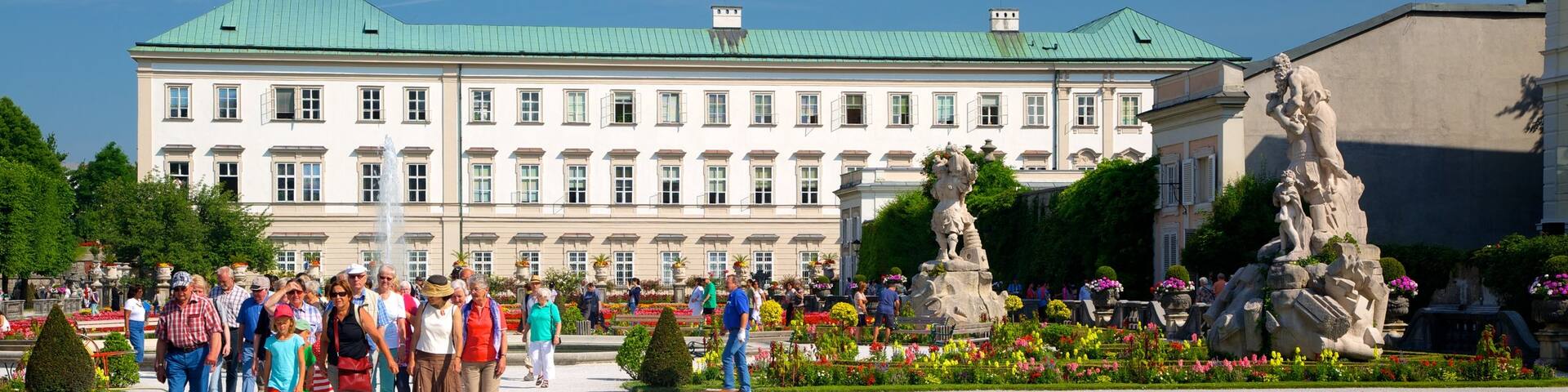 Mirabell Palace and Gardens featuring a statue or sculpture, flowers and château or palace
