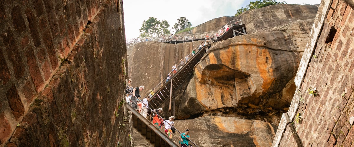 Sigiriya showing hiking or walking and a gorge or canyon as well as a small group of people