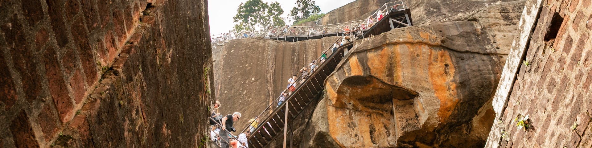 Sigiriya showing hiking or walking and a gorge or canyon as well as a small group of people