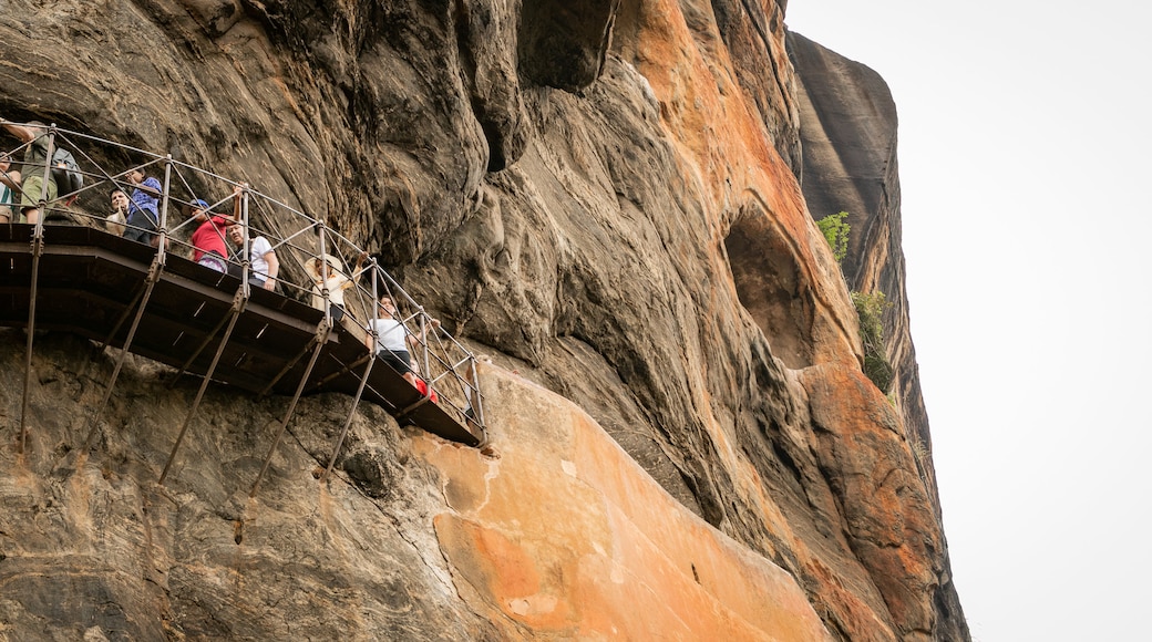 Sigiriya featuring a gorge or canyon and views as well as a small group of people