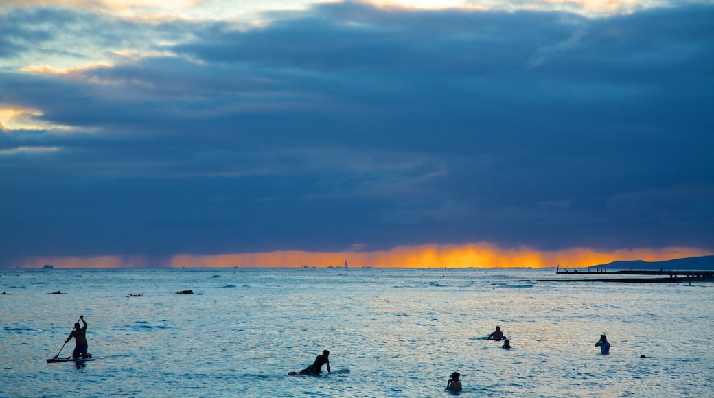 Waikiki Beach showing general coastal views, surfing and a sunset