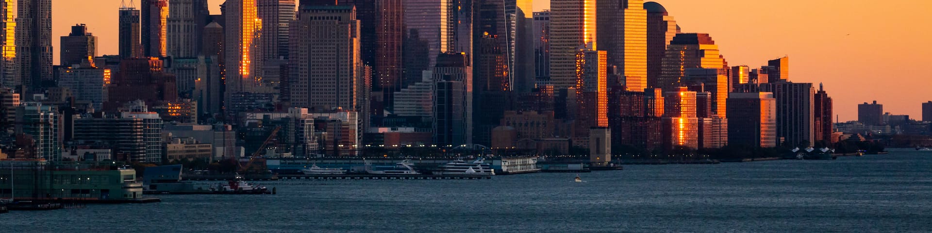 Lower Manhattan showing a bay or harbor, a sunset and a city