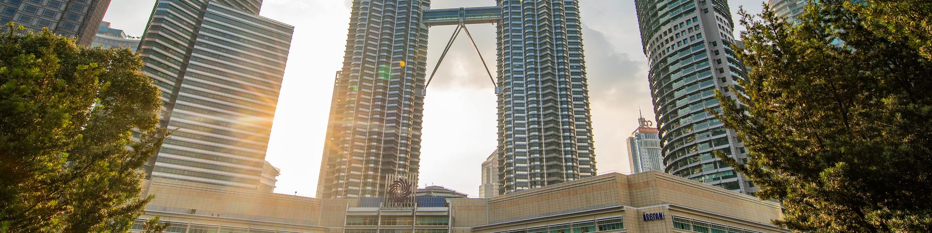 KLCC Park which includes a high rise building, a city and a sunset