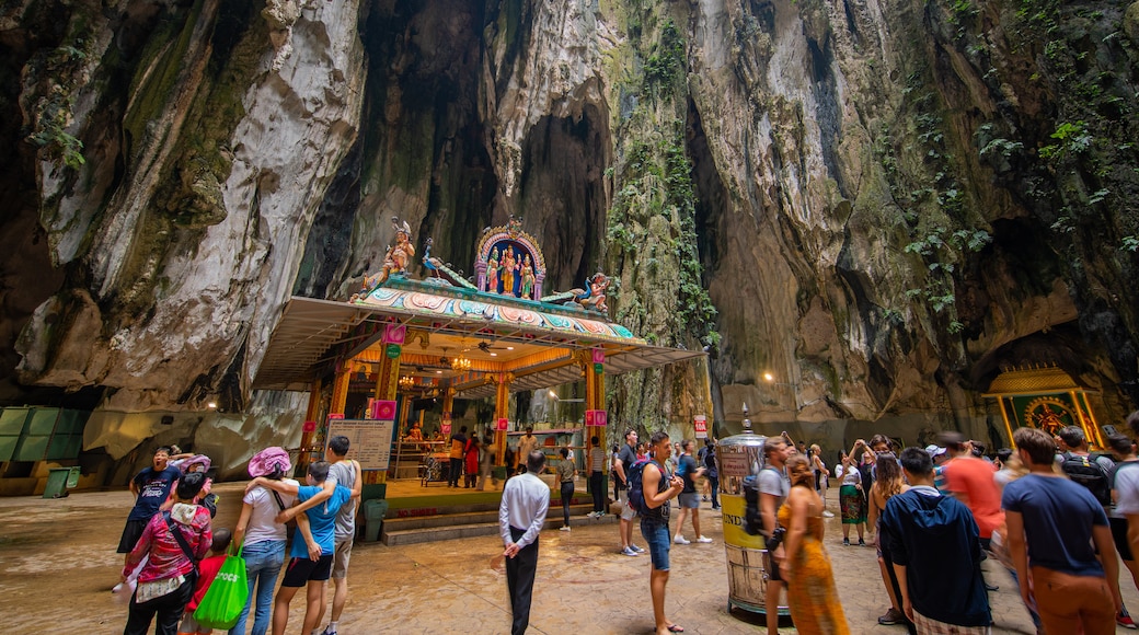 Batu Caves featuring caves and heritage elements as well as a large group of people