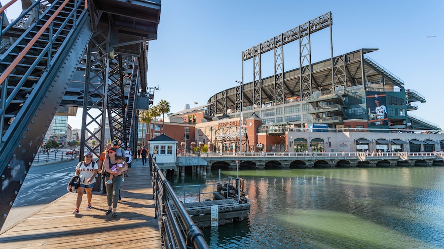 Oracle Park featuring a bay or harbor and street scenes as well as a small group of people