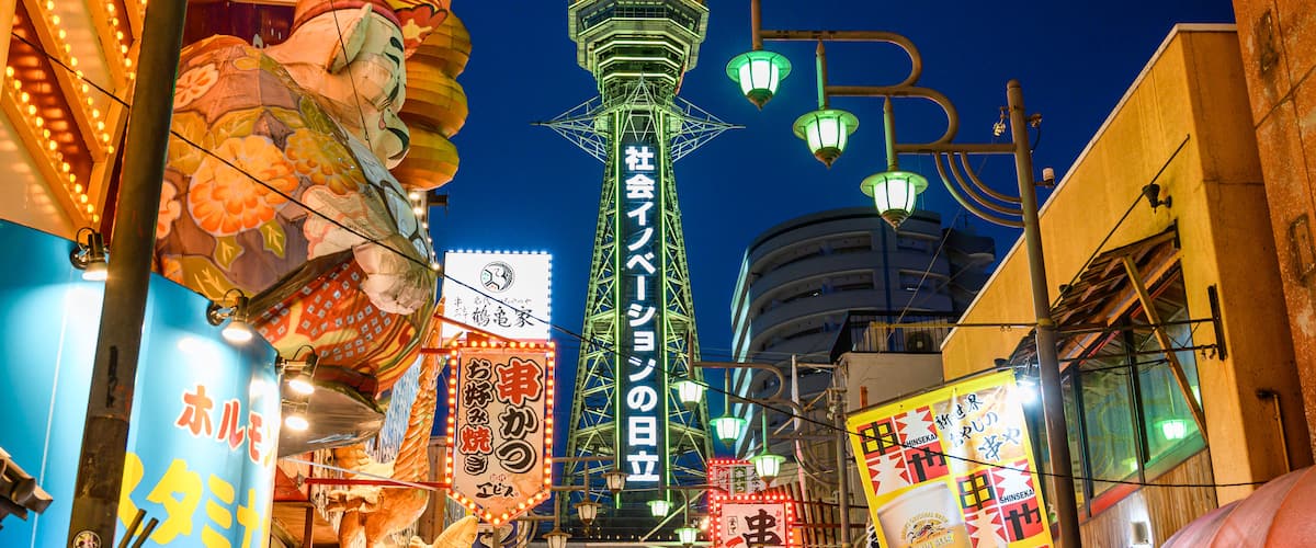 Tsutenkaku Tower which includes night scenes, signage and a city