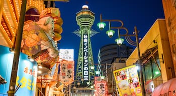 Tsutenkaku Tower which includes night scenes, signage and a city