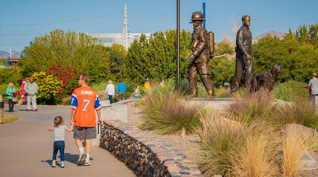 Tempe Beach Park showing a statue or sculpture and a garden as well as a family