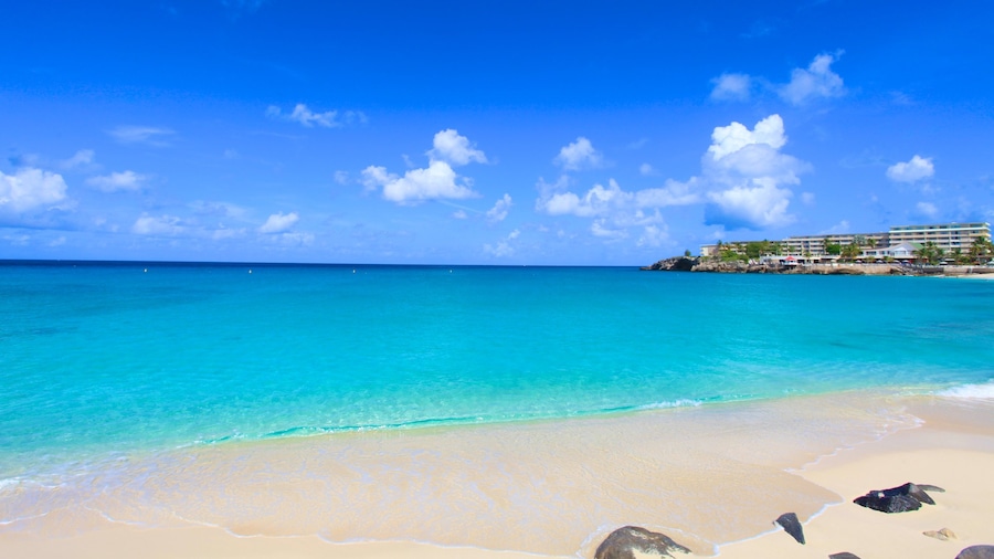 Maho Beach ofreciendo vistas de paisajes, una ciudad costera y una playa de arena