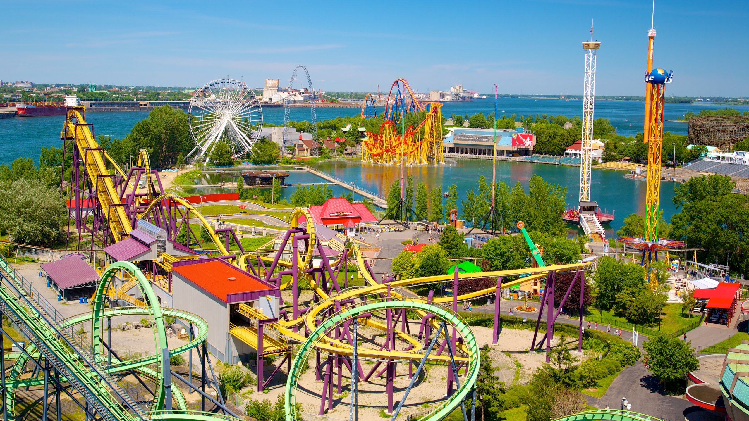 Aerial view of La Ronde amusement park in Montreal with roller coasters and waterfront scenery.