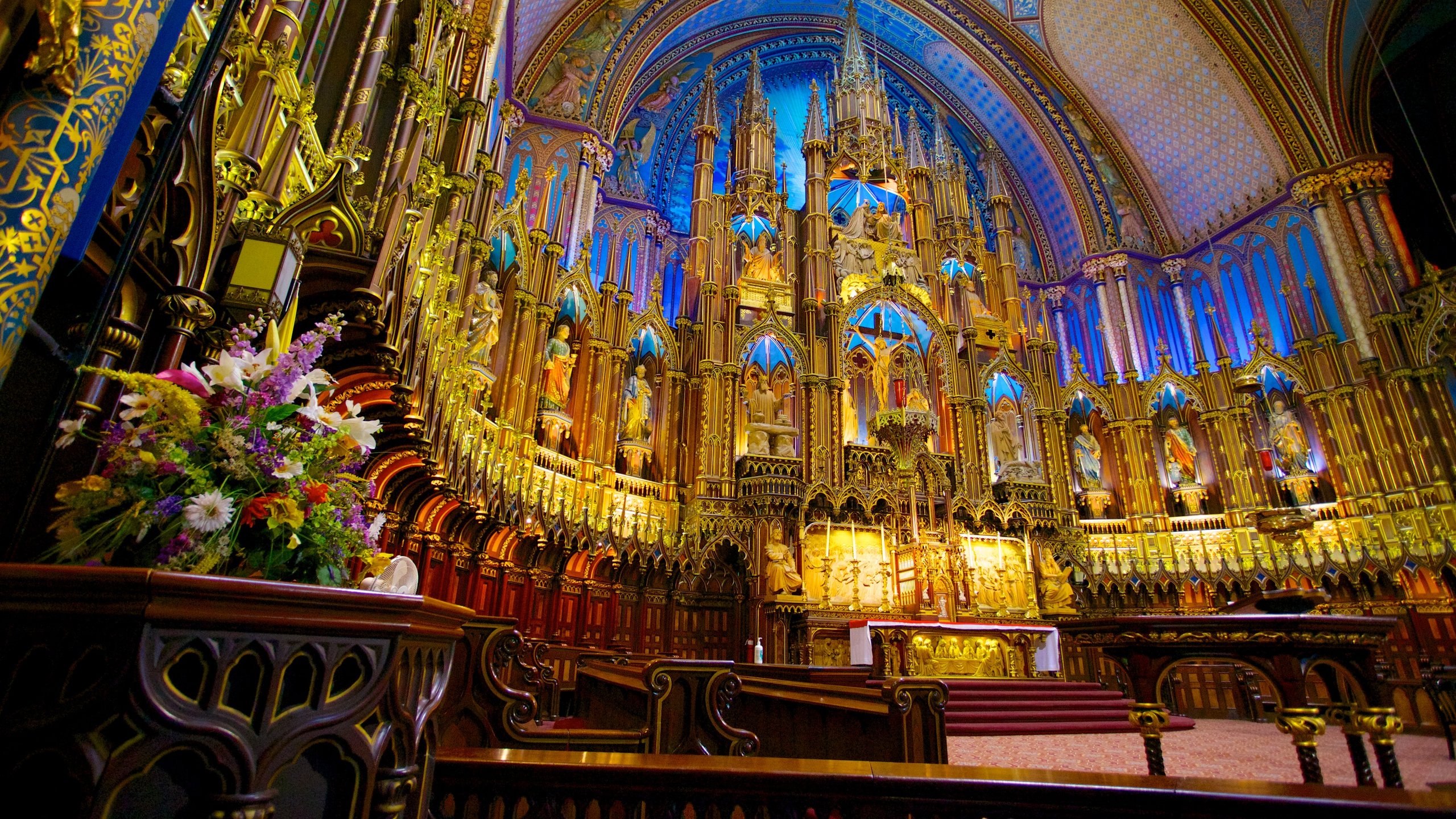Interior view of Notre-Dame Basilica in Old Montreal, showcasing vibrant stained glass and intricate woodwork.
