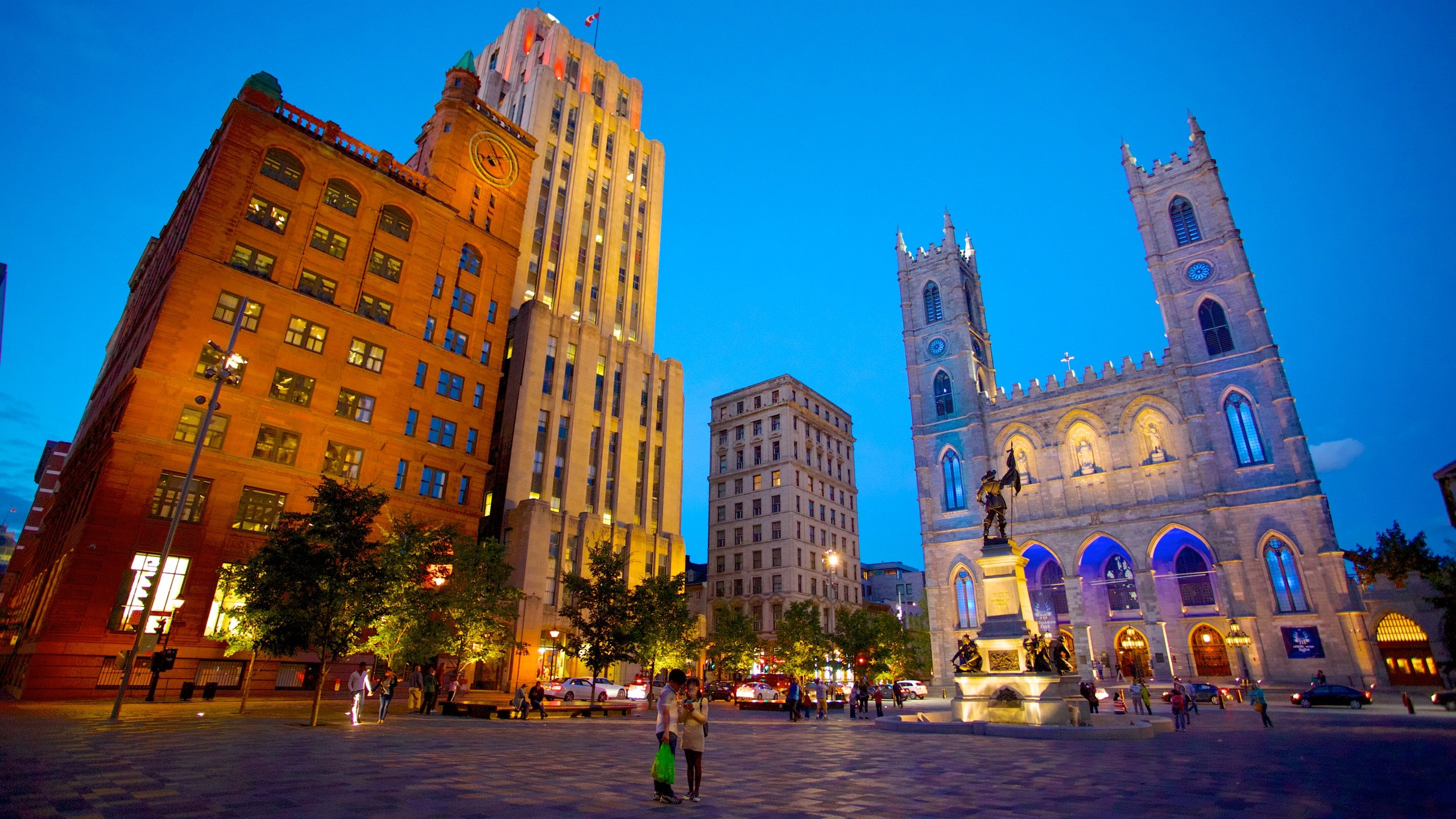 Exterior view of Notre-Dame Basilica in Montreal, featuring Neo-Gothic architecture and vibrant lighting.