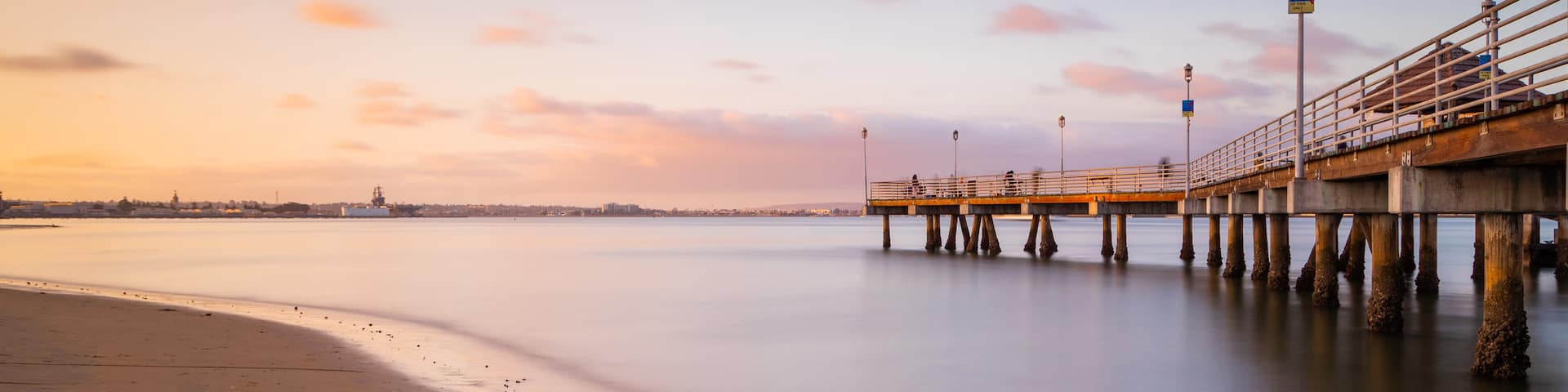 Coronado Ferry Landing featuring general coastal views, a sandy beach and a sunset
