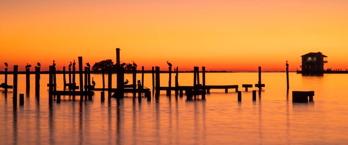 Biloxi which includes general coastal views and a sunset