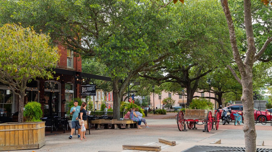 City Market in Savannah, Georgia, featuring outdoor seating under shady oak trees, people strolling by Belford’s restaurant, and a relaxed historic district atmosphere