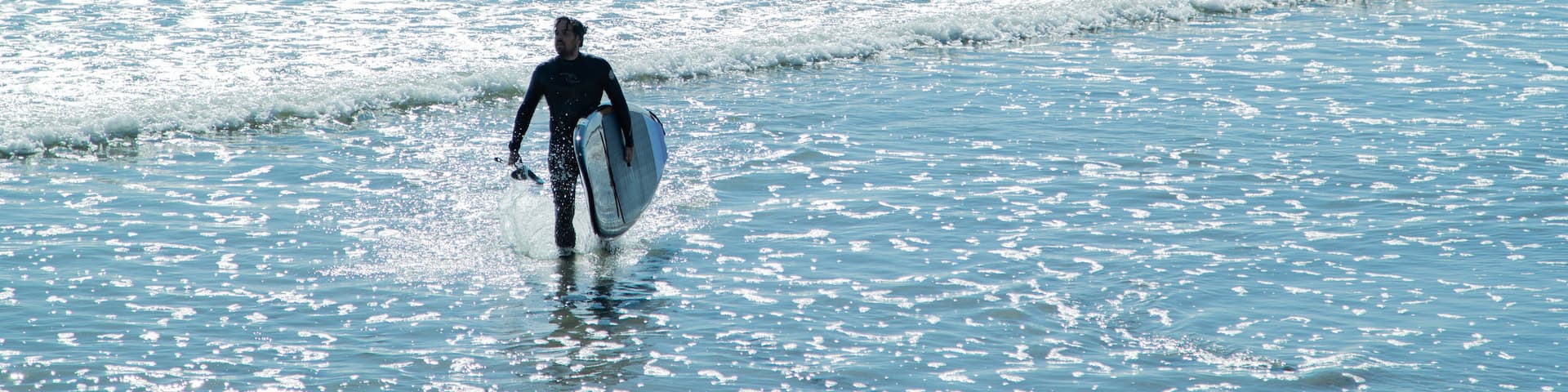 Long Sands Beach featuring general coastal views and surfing as well as an individual male