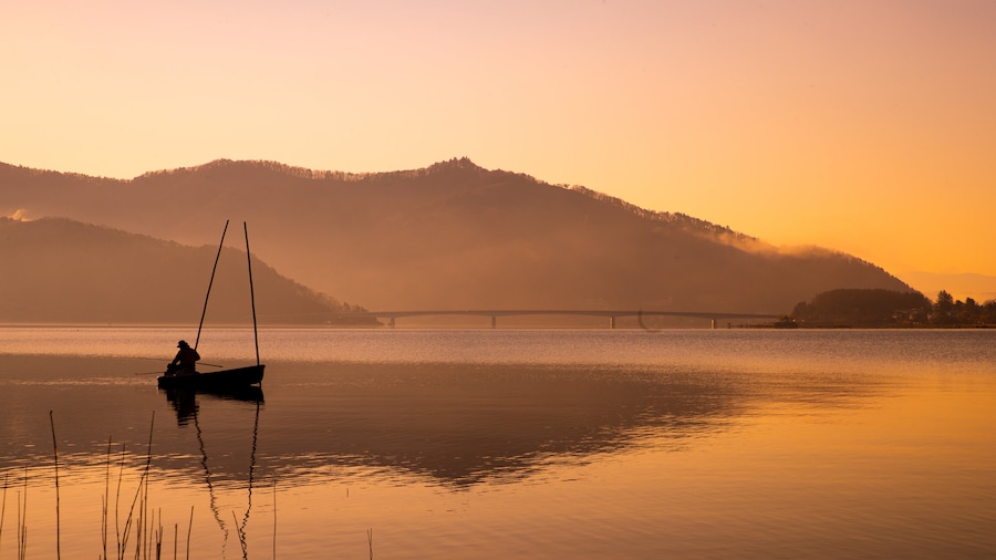 Lake Kawaguchi which includes fishing, a sunset and a lake or waterhole