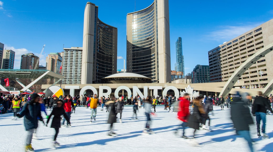 Nathan Phillips Square featuring a city and snow skiing as well as a large group of people