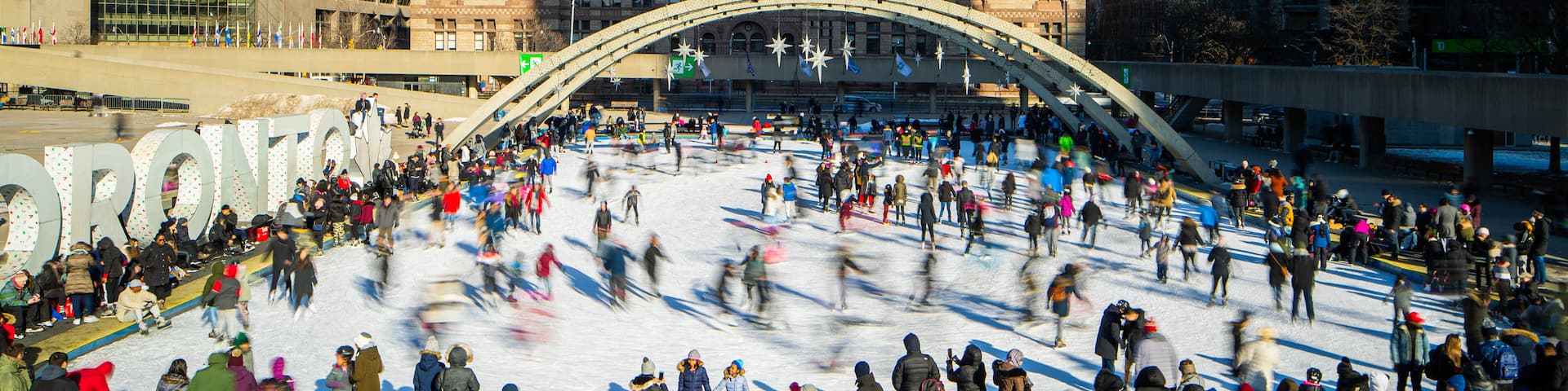 Nathan Phillips Square which includes a city and snow skiing as well as a large group of people