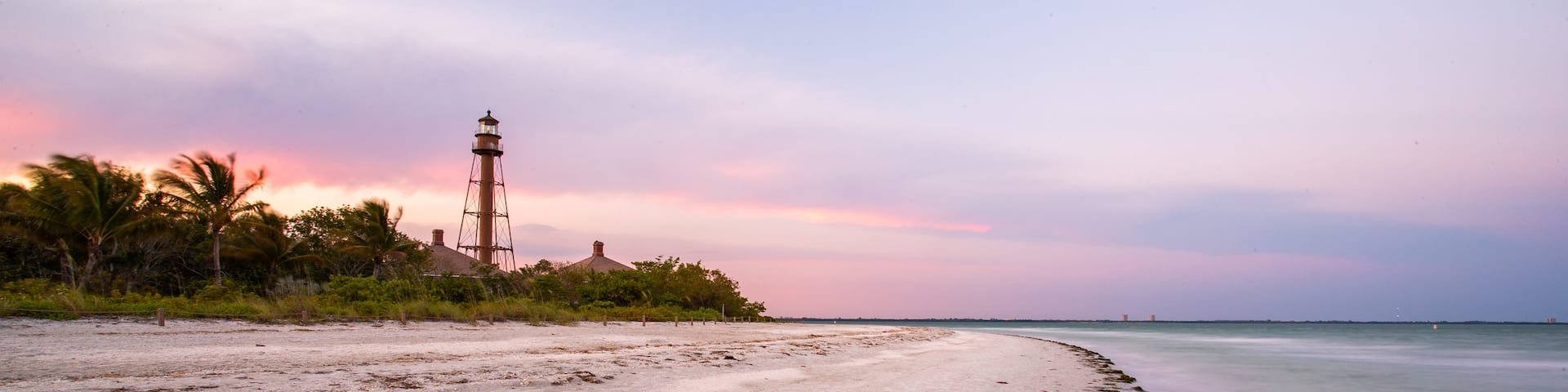 Sanibel Island Lighthouse which includes a beach, general coastal views and a sunset