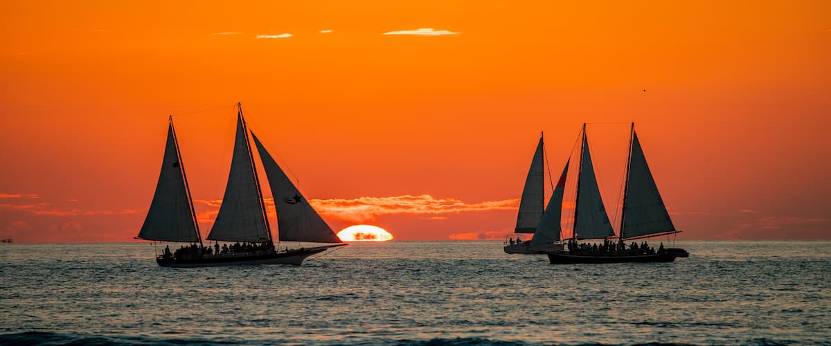 Mallory Square featuring general coastal views, a sunset and sailing