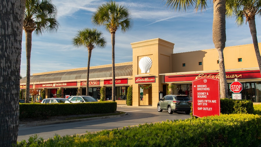 Exterior view of Silver Sands Premium Outlets with storefronts and palm trees in Destin, Florida.
