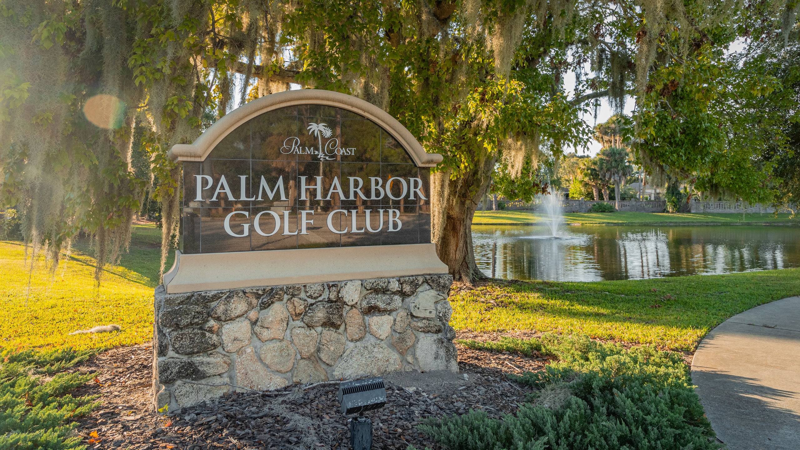 Palm Harbor Golf Club showing a pond and signage