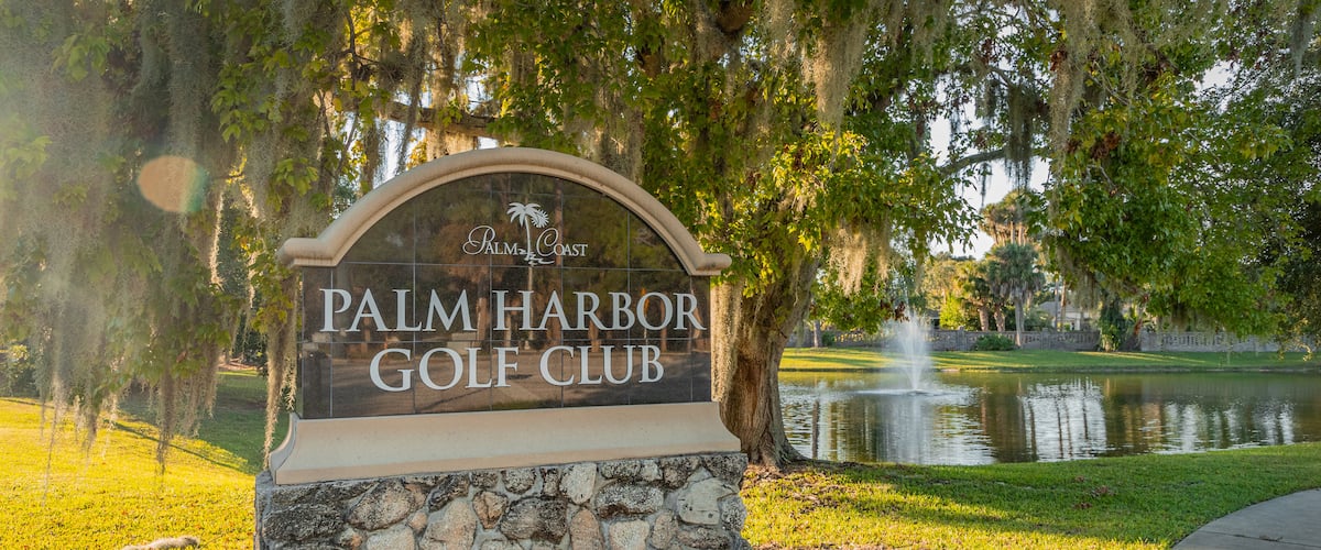 Palm Harbor Golf Club showing a pond and signage