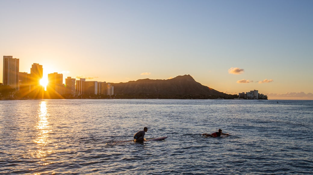 Waikiki showing surfing, a sunset and general coastal views