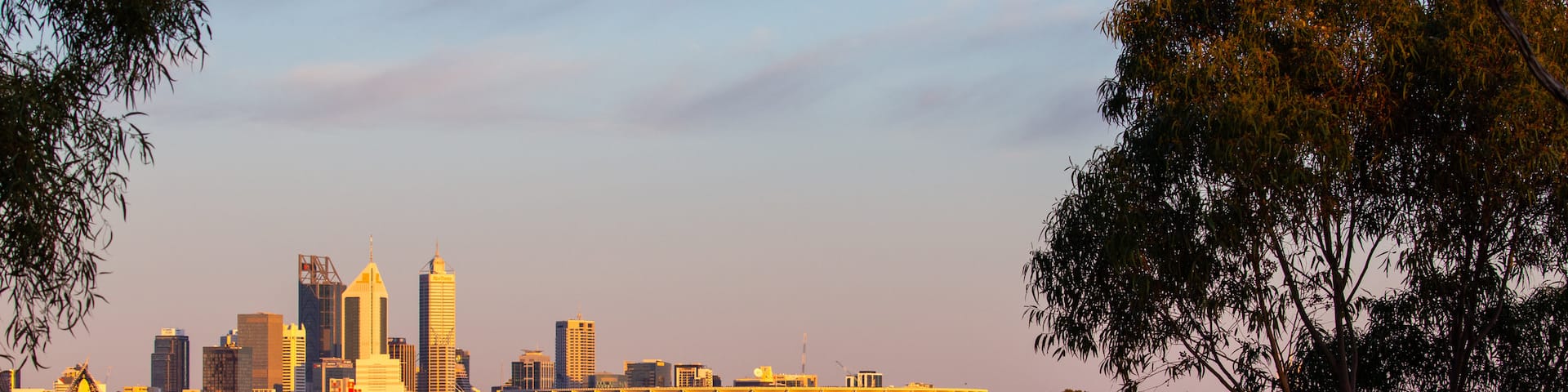Optus Stadium showing a city, a sunset and a river or creek