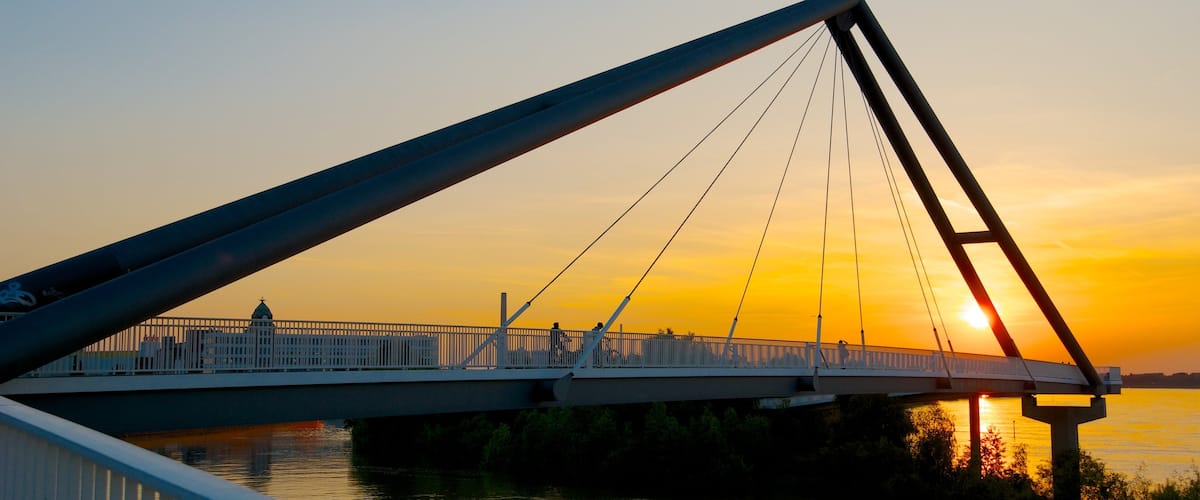 Duesseldorf-Hafen showing a sunset, a bay or harbour and a suspension bridge or treetop walkway