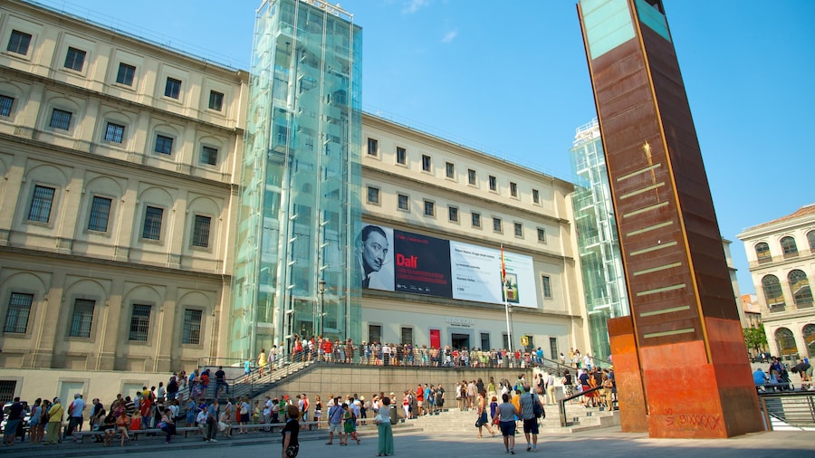 Reina Sofia Museum which includes a square or plaza and modern architecture as well as a large group of people