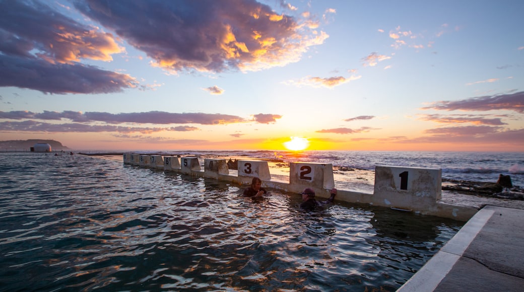 Merewether Ocean Baths featuring a sunset, general coastal views and a pool