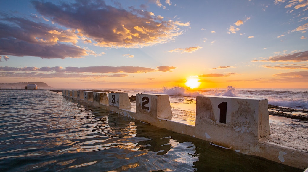 Merewether Ocean Baths which includes signage, general coastal views and a sunset