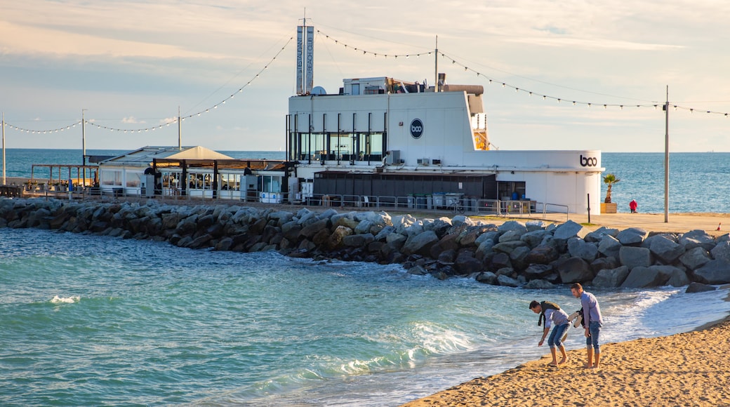 Mar Bella Beach which includes general coastal views and a beach as well as a couple