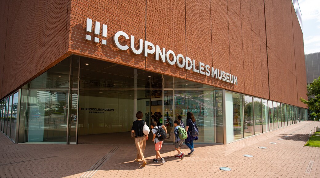 Cupnoodles Museum featuring signage as well as a family