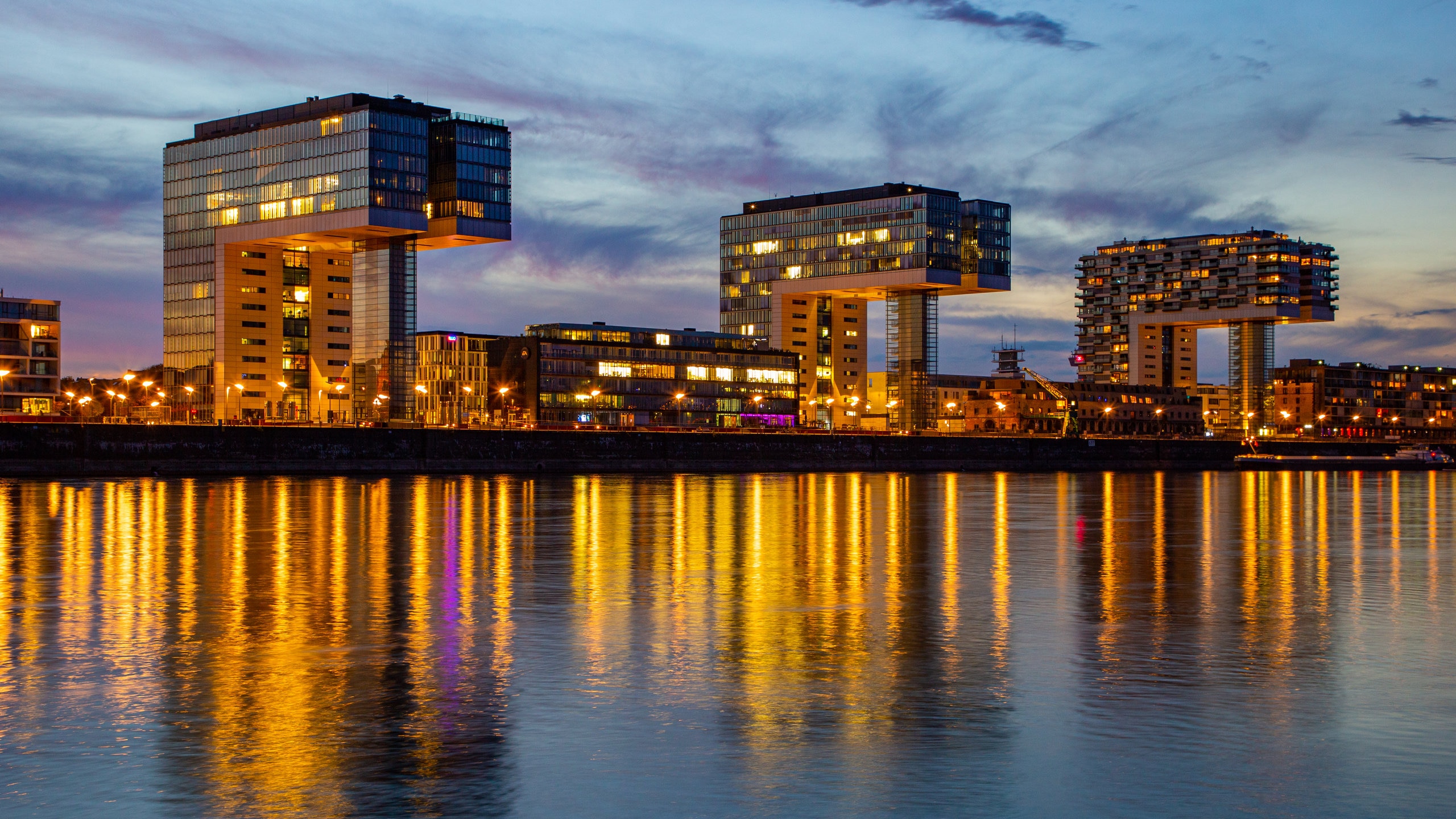 Rheinau Harbour which includes modern architecture, a sunset and a river or creek