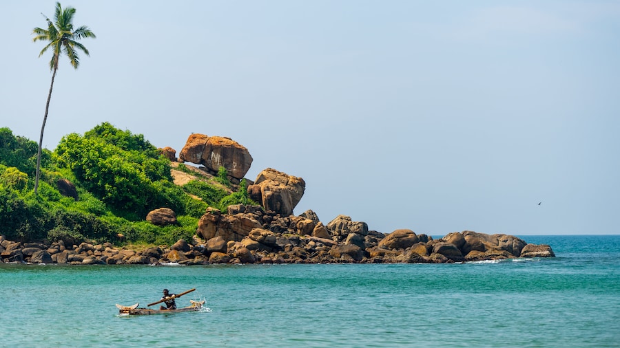 Kovalam Beach showing general coastal views, rocky coastline and kayaking or canoeing