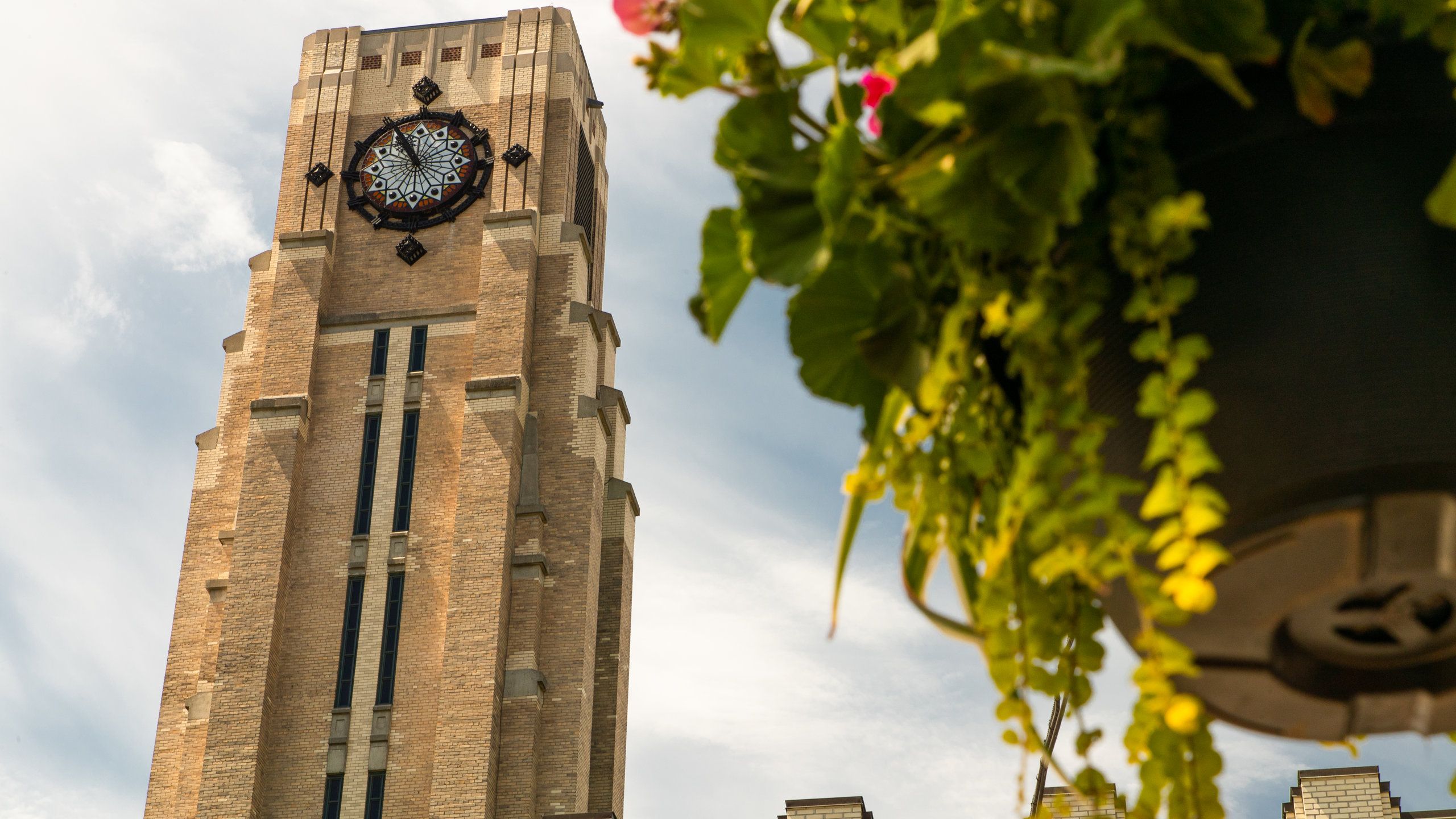 Art Deco architecture of Atwater Market in Montreal with vibrant flowers in foreground.