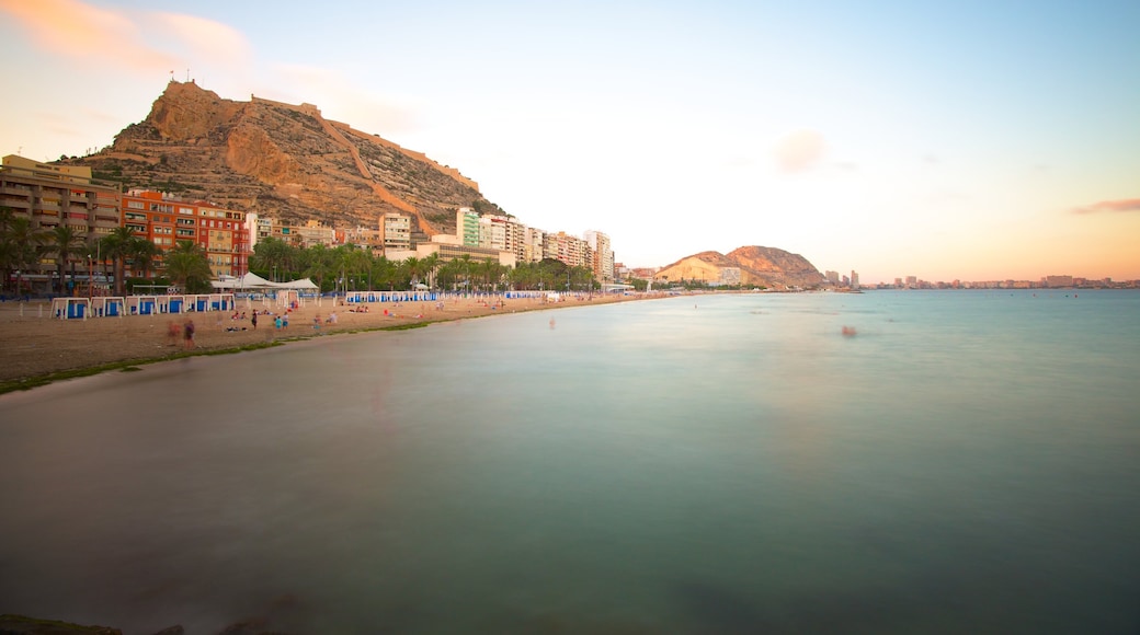 Postiguet Beach which includes a sunset, landscape views and a coastal town