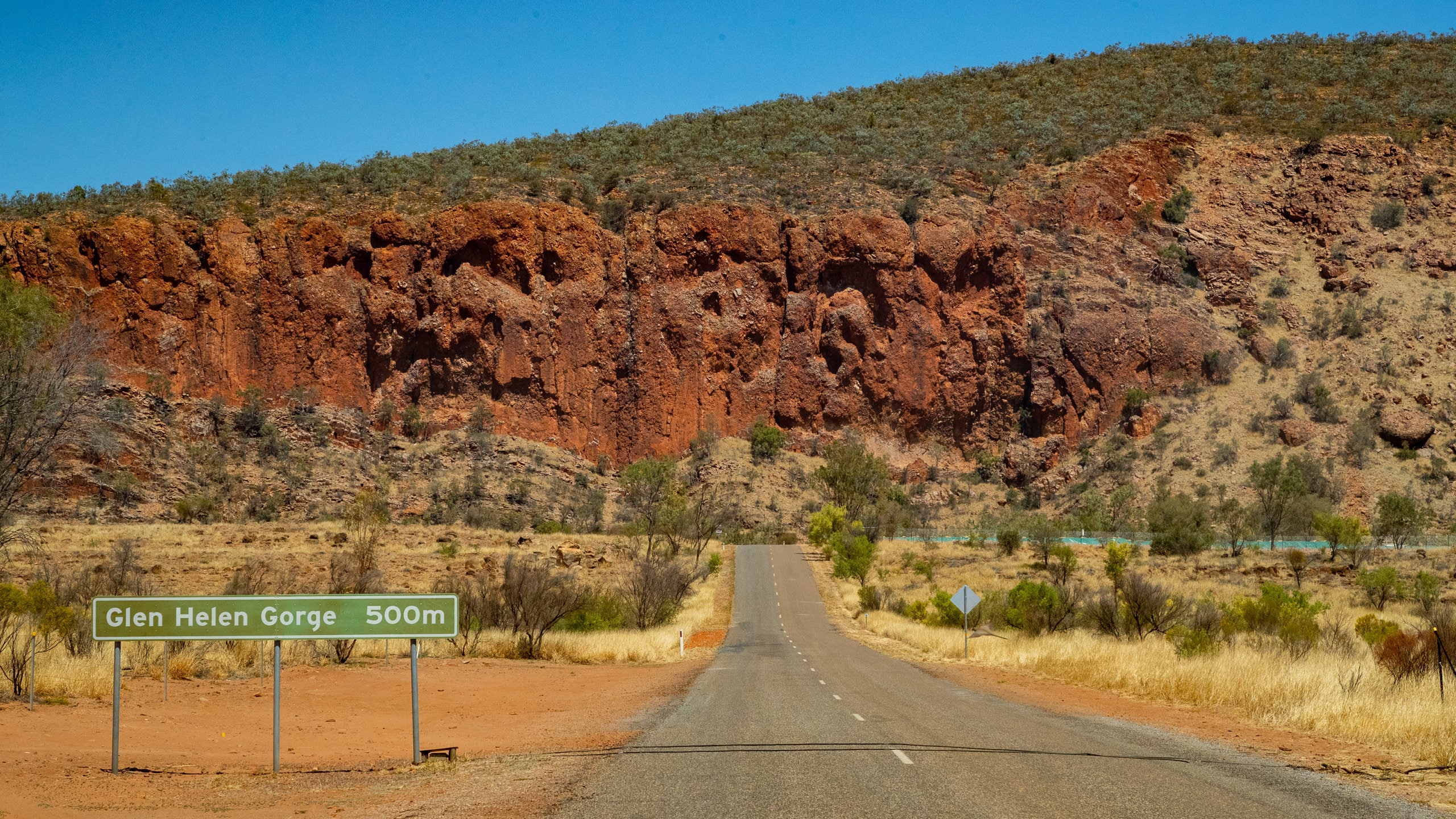 Glen Helen Gorge featuring desert views, tranquil scenes and signage