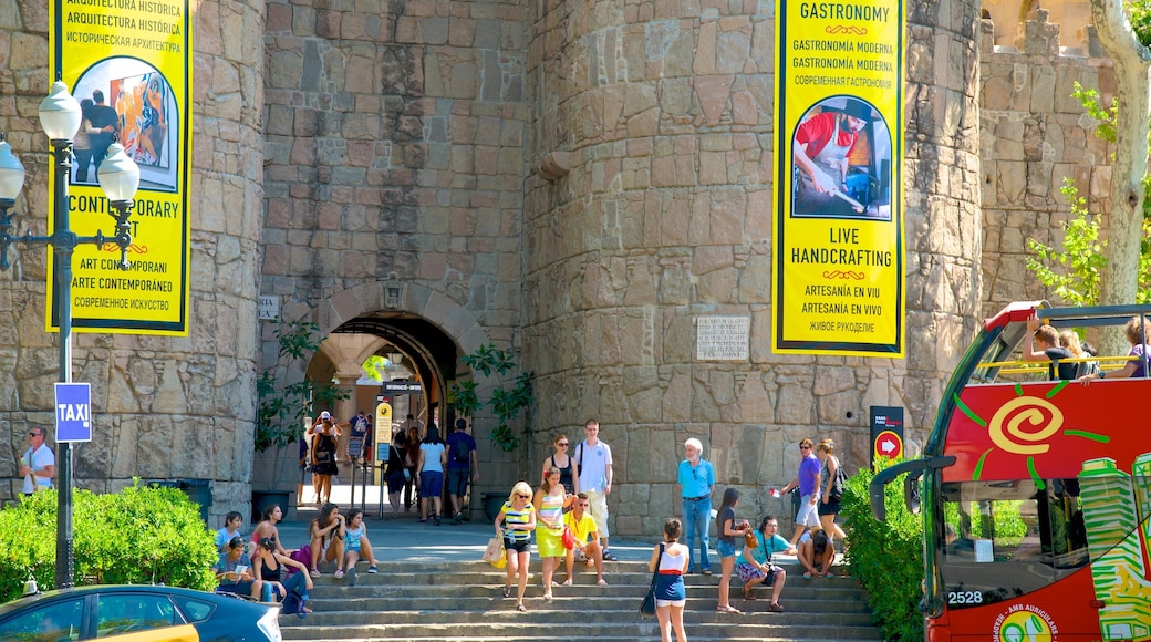 Poble Espanyol som viser skilt og liten by eller landsby i tillegg til en stor gruppe med mennesker