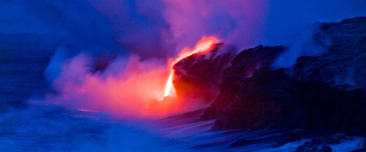 Pahoa que incluye escenas nocturnas, costa rocosa y neblina o niebla