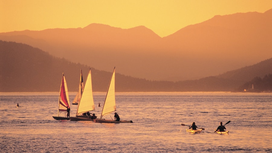 Sailboats and kayakers enjoying a sunset at Jericho Beach in Vancouver.
