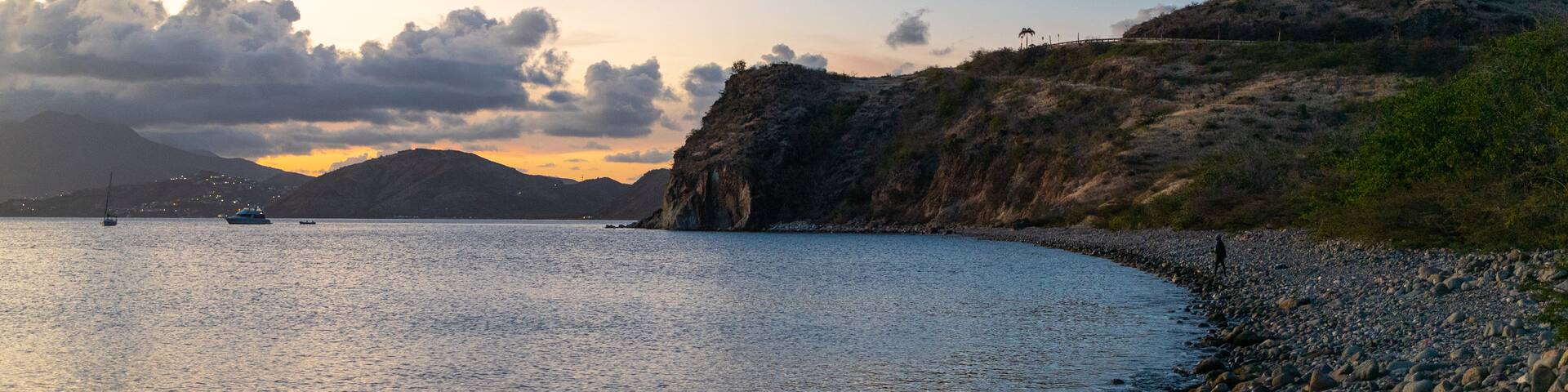 St. Kitts featuring a pebble beach, a sunset and general coastal views