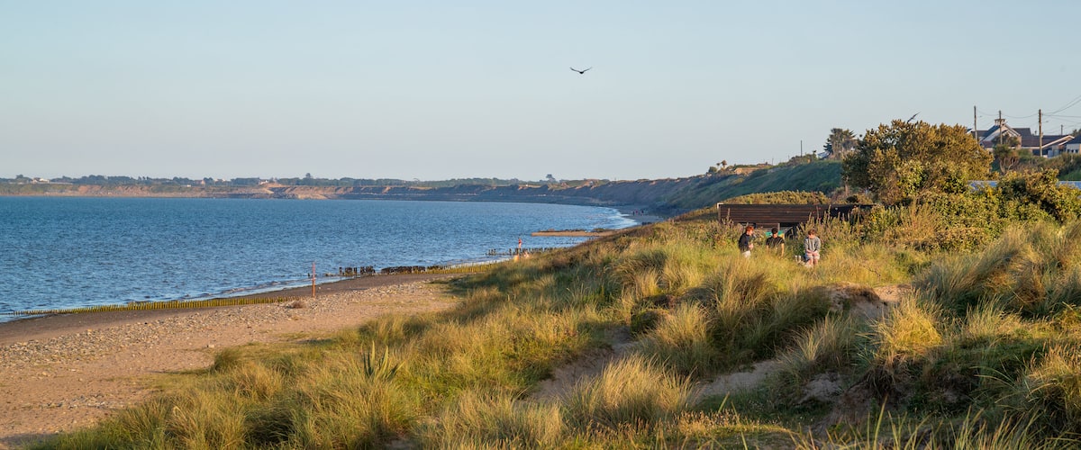 Rosslare Beach showing a sunset, general coastal views and a beach